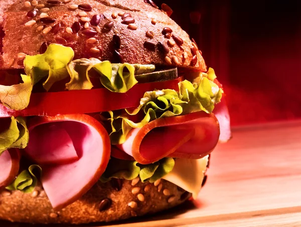 Half of hamburger with ham on wooden board . — Stock Photo, Image