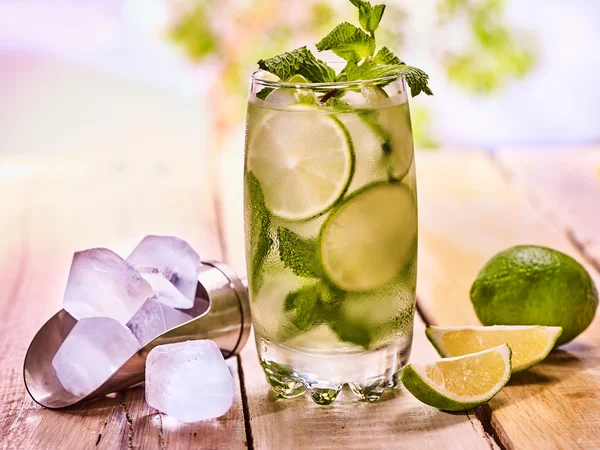 On wooden boards is glass with mohito and scoop ice. — Stock Photo, Image