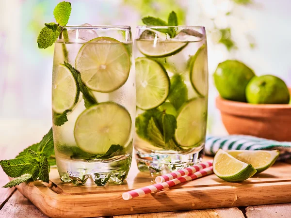 Op houten planken is glas met mohito en kalk. — Stockfoto