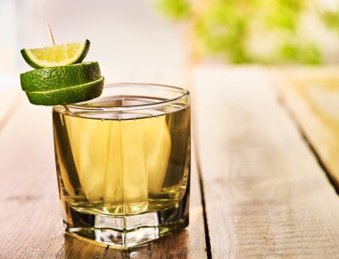Ahşap tahtalarda alkol yeşil limon içecek ile cam .