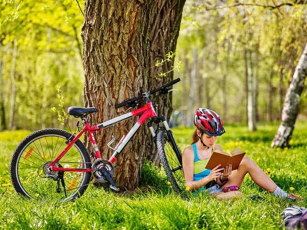 Велосипедна дівчина читає книгу на відпочинку біля велосипеда . . — стокове фото