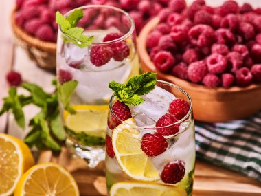 Ahşap kurullarında ahududu mohito ve kireç ile bardaklar.