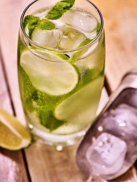 On wooden boards is glass with mohito and scoop ice. — Stock Photo, Image