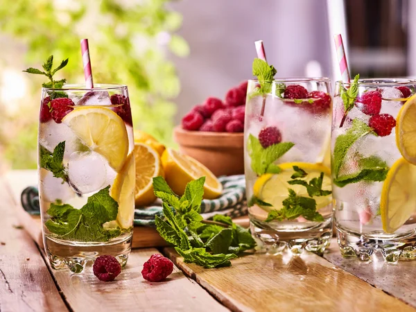 Sur les planches en bois sont des verres avec mojito framboise et citron vert . — Photo