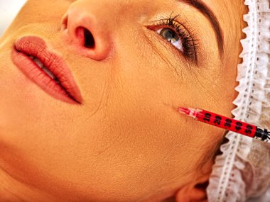 Botox enjeksiyonları veren spa salonda orta yaşlı kadın.