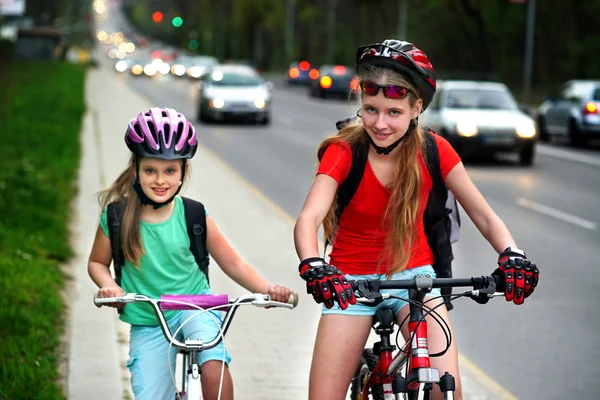 Flickor barn cykla på Yellow Bike Lane. Bilar är väg. — Stockfoto