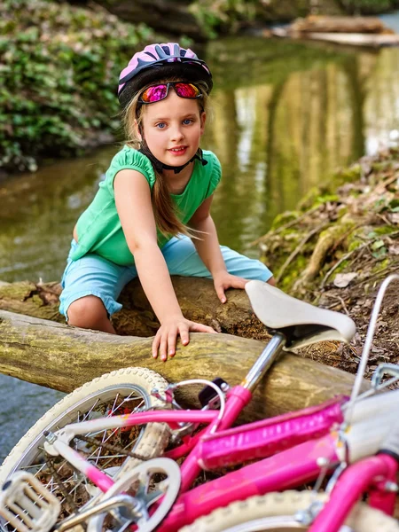 Menina na bicicleta fording através de água em log no parque . — Fotografia de Stock