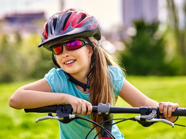 Dziewczyna jeździ na rowerze zielona trawa w parku na zewnątrz. — Zdjęcie stockowe