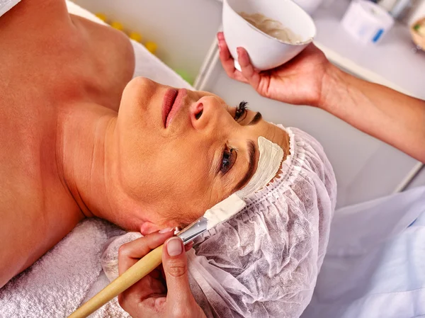 Woman middle-aged take face massage in spa salon. — Stock Photo, Image