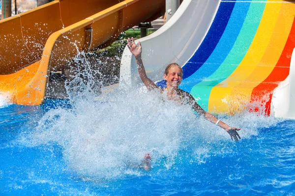 Kind auf Wasserrutsche im Aquapark zeigt Daumen hoch. — Stockfoto