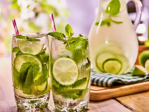 On wooden table is glass jug and cocktail with drink. — Stock Photo, Image