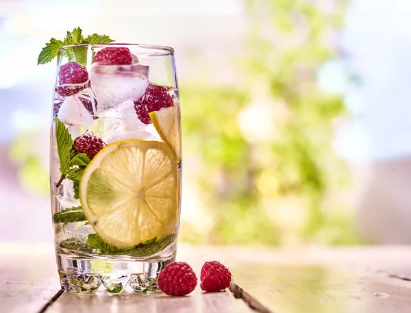 Mojito de framboesa com cubos de vidro de gelo. Ao ar livre . — Fotografia de Stock