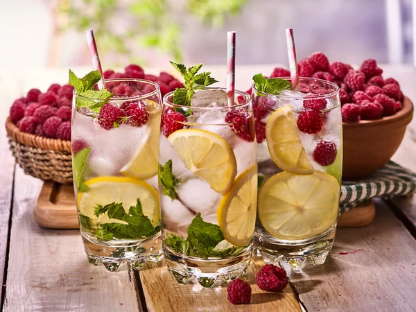 Sur des planches en bois est des verres avec mohito framboise et citron vert . — Photo