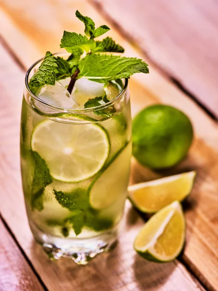 stock image On wooden boards is glass with mohito and lime.