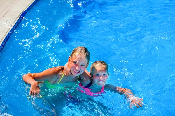 Duas crianças agradáveis menina nadar na piscina . — Fotografia de Stock