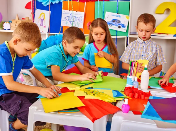 Kinderen maken iets uit gekleurd papier. — Stockfoto