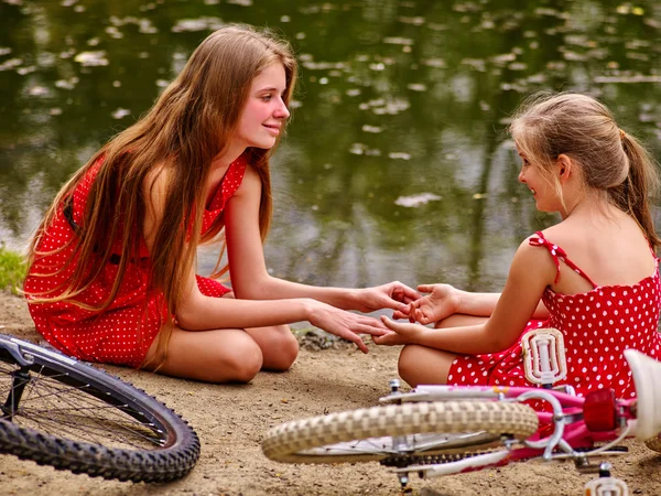 Happy mother with daughter rides bicycle and sitting on beach. — Stock Photo, Image