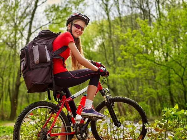 Girl rides bicycle on green grass in park outdoor. — Stock Photo, Image