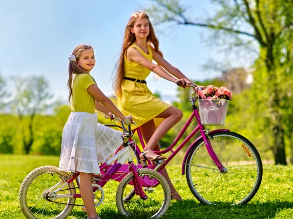 Mädchen im roten Tupfen-Kleid fährt mit Fahrrad in Park. — Stockfoto