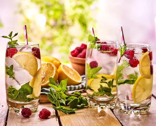 Sur les planches en bois sont des verres avec mojito framboise et citron vert . — Photo