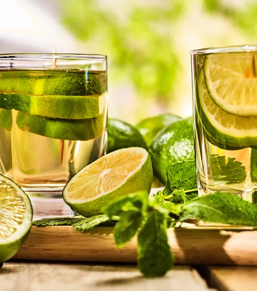 Ahşap Komiteler gözlük yeşil şeffaf içki ve limon ile.