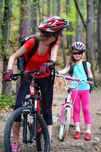Mãe e filha usando capacete estão de bicicleta  . — Fotografia de Stock