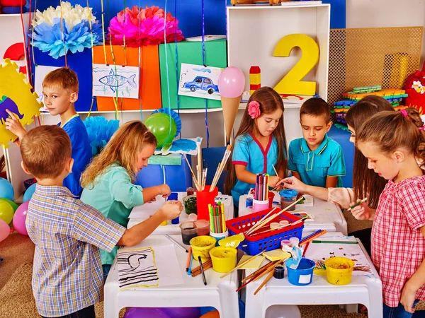 Niños con maestra pintando sobre papel en el jardín de infantes  . — Foto de Stock