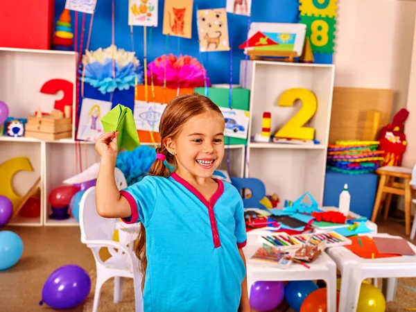 Mädchen hält Origami-Flugzeug in Grundschule. — Stockfoto