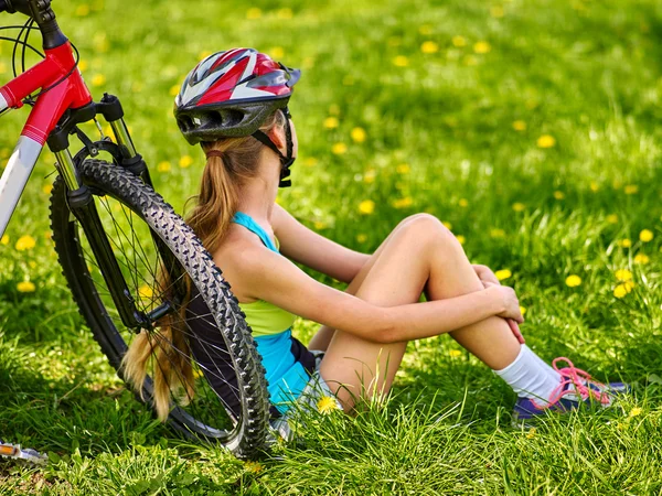 Bicicletas menina ciclismo usando capacete sentado perto de bicicleta . — Fotografia de Stock