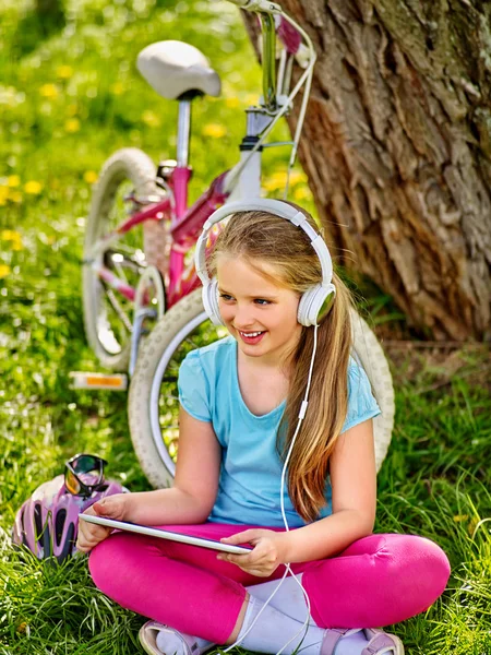 Chica de la bicicleta con auriculares mirando en la tableta pc . —  Fotos de Stock
