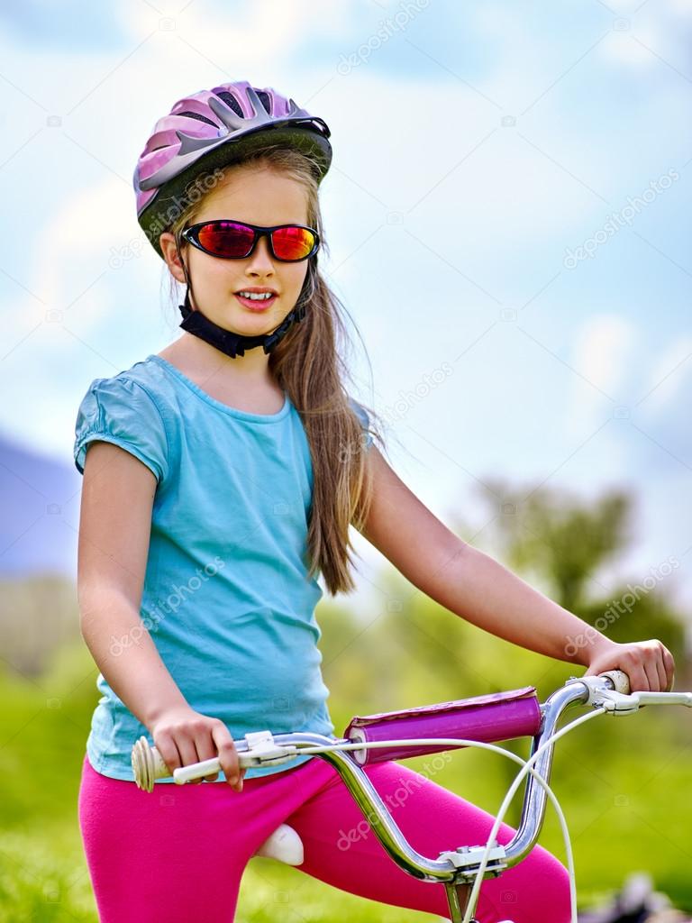 Bikes cycling girl wearing helmet rides bicycle aganist blue sky