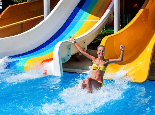 Child on water slide at aquapark show thumb up. — Stock Photo, Image