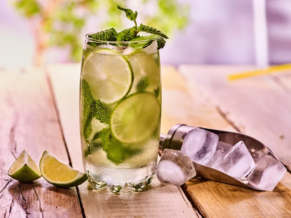 On wooden boards is glass with mohito and scoop ice. — Stock Photo, Image