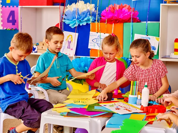 Los niños con maestro están haciendo algo con papel de colores. . — Foto de Stock