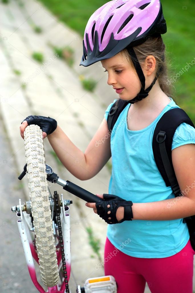 Girls child cycling pump up bicycle tire. — Stock Photo © poznyakov