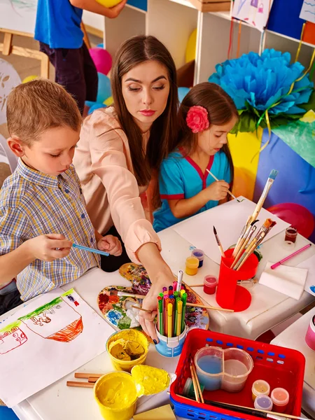 Kinderen meisje en jongen met borstel schilderij in basisschool. — Stockfoto