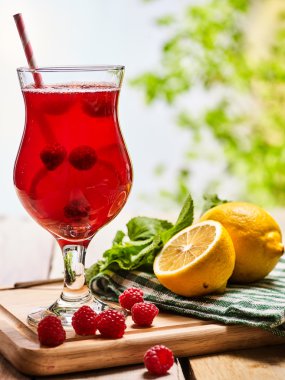 Ahşap üzerinde ahududu kokteyli ile buz gibi içecek cam .