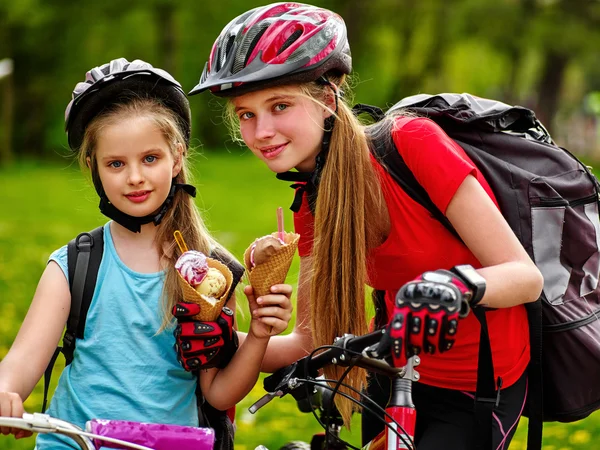 Ποδήλατο κορίτσια με σακίδιο τρώει παγωτό κώνο στο πάρκο. — Φωτογραφία Αρχείου