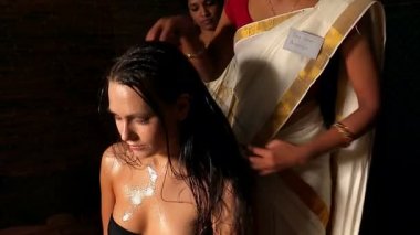 Genç kadın baş ayurveda tedavi sahip. Hintli kadın masöz spa salonda.