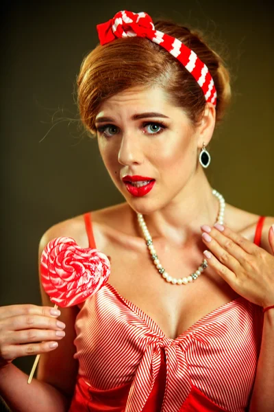 Girl in pin-up style hold striped lollipops. — Stock Photo, Image