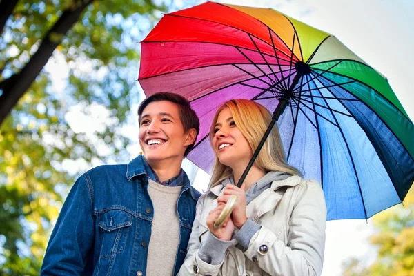 Pareja cariñosa en una cita bajo paraguas . — Foto de Stock