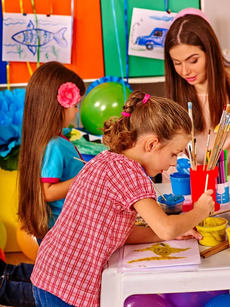 Niños con maestra pintando sobre papel en el jardín de infantes  . —  Fotos de Stock