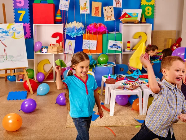 Groep kinderen houden van origami vliegtuig in de kleuterschool . — Stockfoto