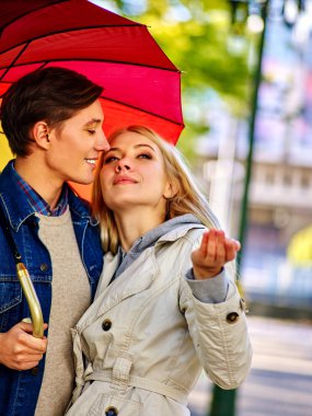 Sonbahar Park şemsiyesi altında tarihte seven Çift.