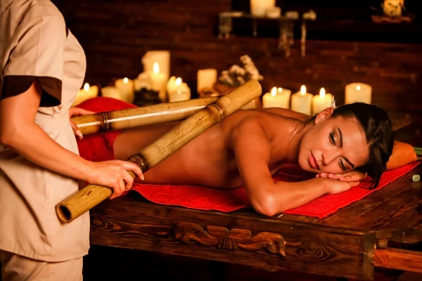 Mladá žena mají bambusové hole terapie masáž. — Stock fotografie
