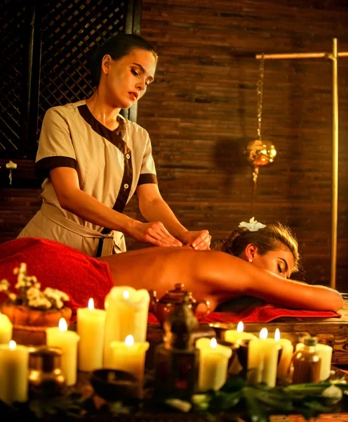 Femme couchée sur un lit de spa de massage en bois luxueux . — Photo