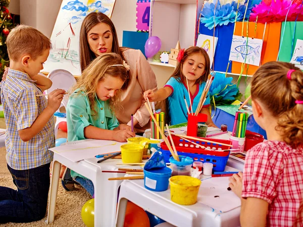 Kinder mit Lehrerin malen in der Schule auf Papier. — Stockfoto