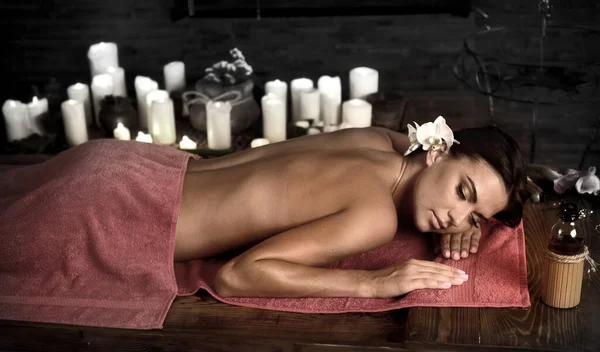 Massage kvinna tillbaka i skönhet spa med levande ljus — Stockfoto