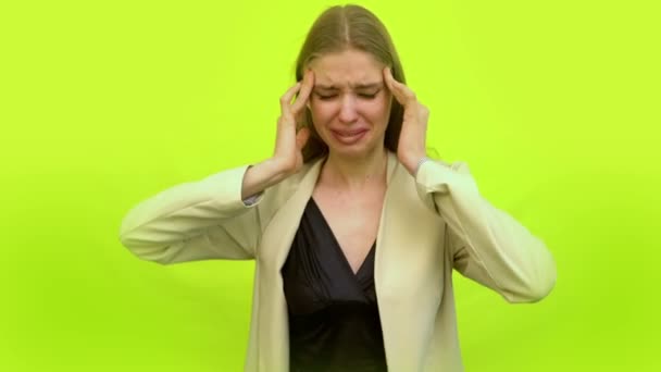Mulher com enxaqueca chorando na parede do estúdio — Vídeo de Stock