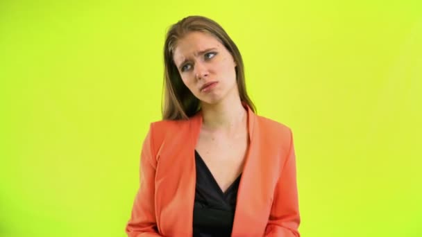 Kvinna tittar på handled klocka i rymden studio på gul bakgrund — Stockvideo